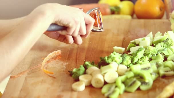 Woman peeling carrot with peeler — Stok video