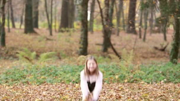 Девушка бросает листья в парке — стоковое видео