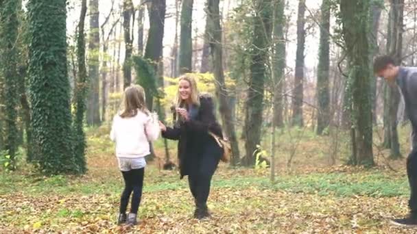 Familie gooien bladeren in park — Stockvideo