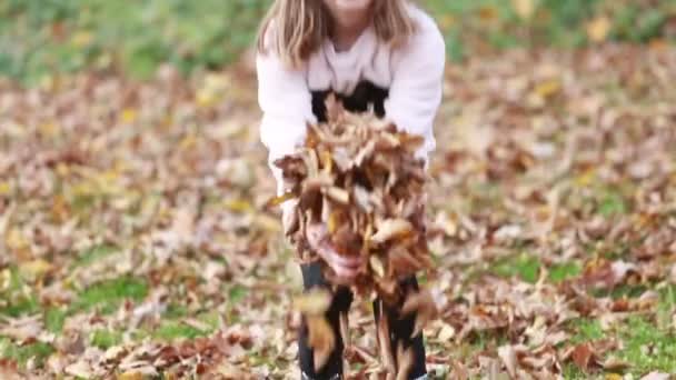 Mädchen wirft Blätter in Park — Stockvideo