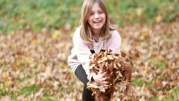 Girl throwing leaves in park — Stock Video