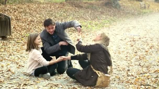 Familie sitzt auf Gehweg im Park — Stockvideo