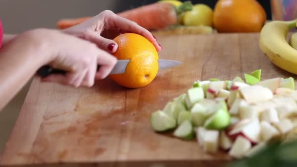 Женщина режет апельсин — стоковое видео