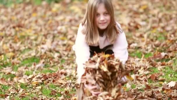 Девушка бросает листья в парке — стоковое видео
