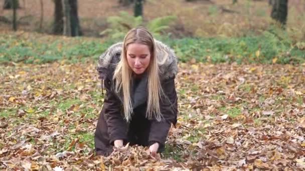 Женщина бросает листья в воздух — стоковое видео