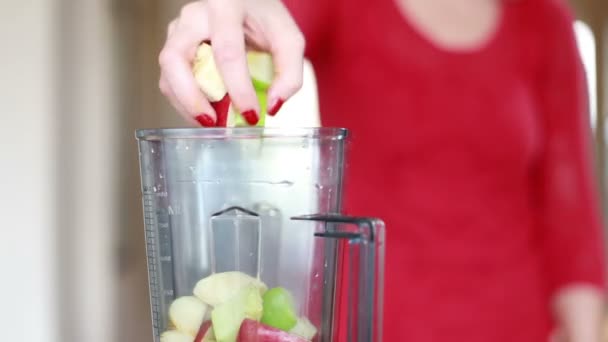 Mano de mujer poniendo frutas en la licuadora — Vídeo de stock