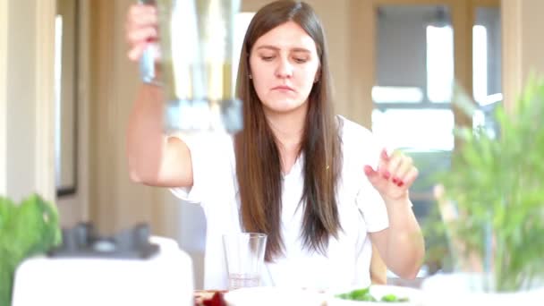 Frau gießt grünen Smoothie ins Glas — Stockvideo