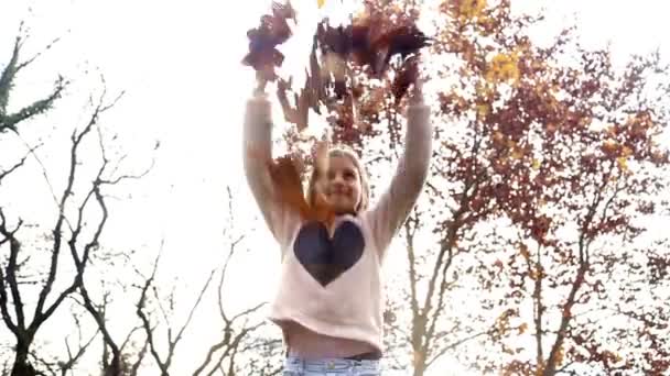 女の子は空気中の葉を投げ — ストック動画