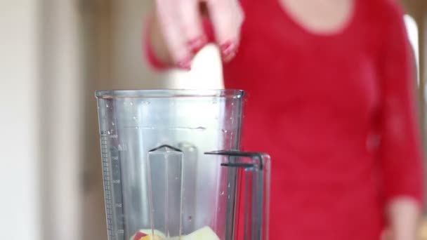 Woman putting fruits into blender — Stock Video