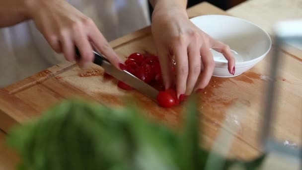 Жінка руками ріже вишневі помідори — стокове відео