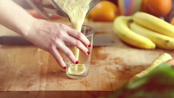 Mulher derramando smoothie fruta em vidro — Vídeo de Stock
