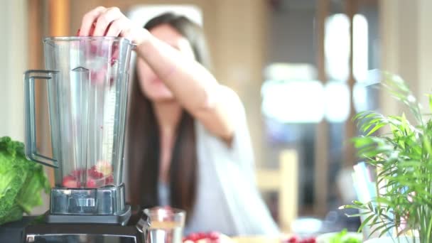 Mujer poniendo frutas en la licuadora — Vídeo de stock