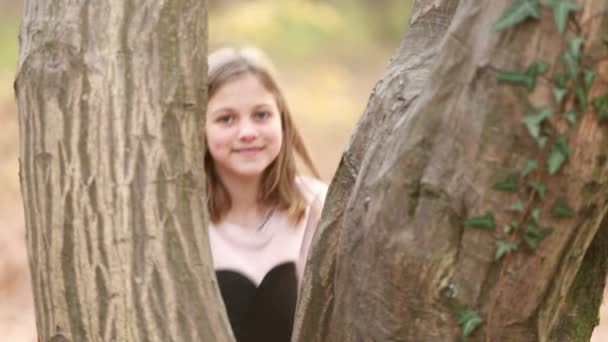 Chica de pie junto al árbol — Vídeo de stock