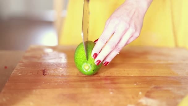 Frau schneidet Avocado mit der Hand — Stockvideo