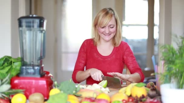 Blonde woman chopping apple — Stockvideo