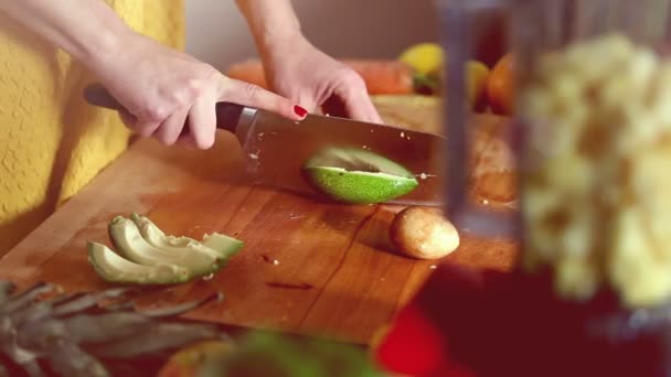 Frau schneidet Avocado mit der Hand — Stockvideo