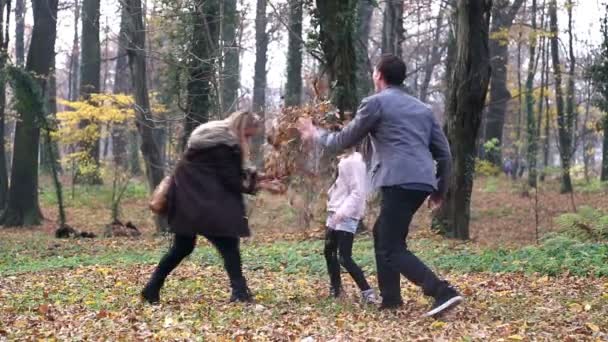 Familie gooien bladeren in park — Stockvideo