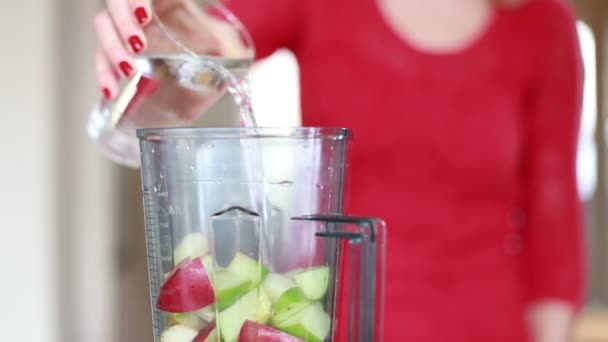 Vrouw stromende water in de blender — Stockvideo