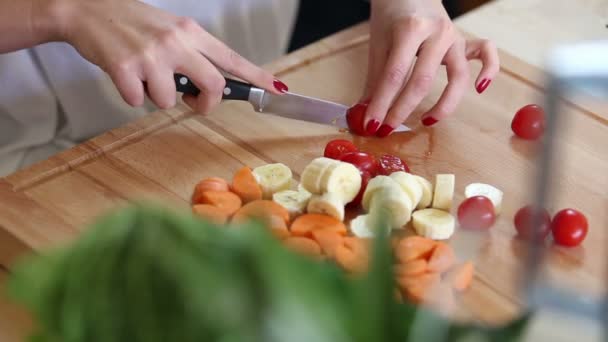 Vrouw snijden cherry tomaten — Stockvideo