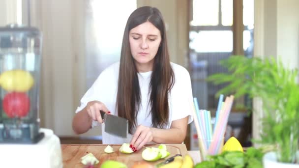 Женщина режет яблоко — стоковое видео