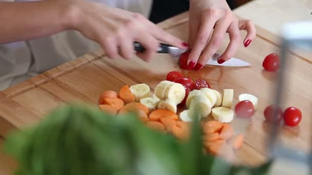 Vrouw handen snijden cherry tomaten — Stockvideo