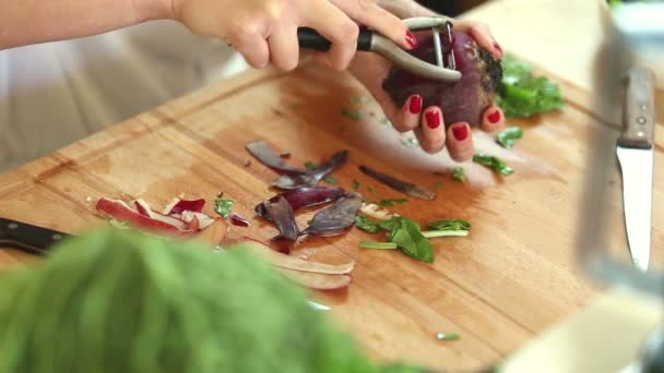 Kvinnan peeling rödbetor med potatisskalare — Stockvideo