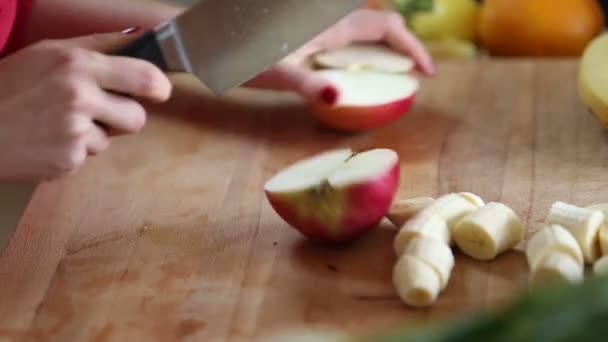 Женщина режет яблоко — стоковое видео