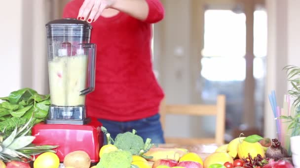 Mujer mezclando frutas en licuadora — Vídeos de Stock