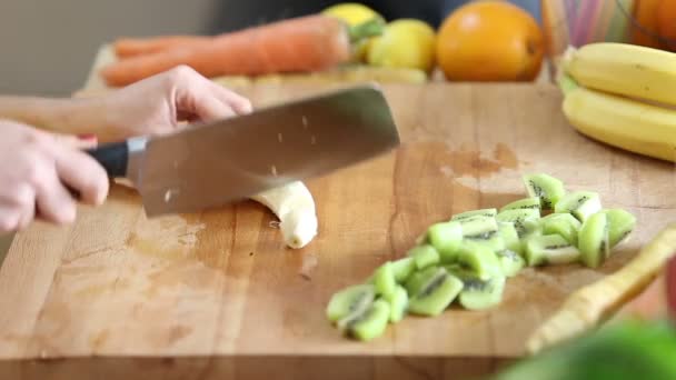 Frau schneidet geschälte Banane — Stockvideo