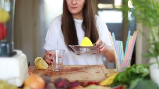 Жінка вливає лимонний сік у склянку — стокове відео