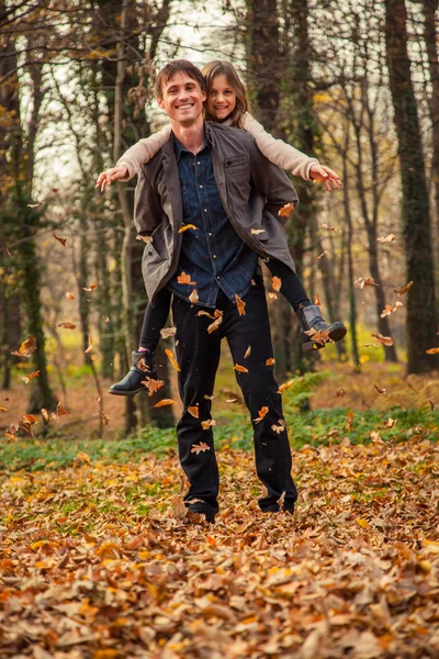 Daughter rides father on piggyback — Stock Photo, Image