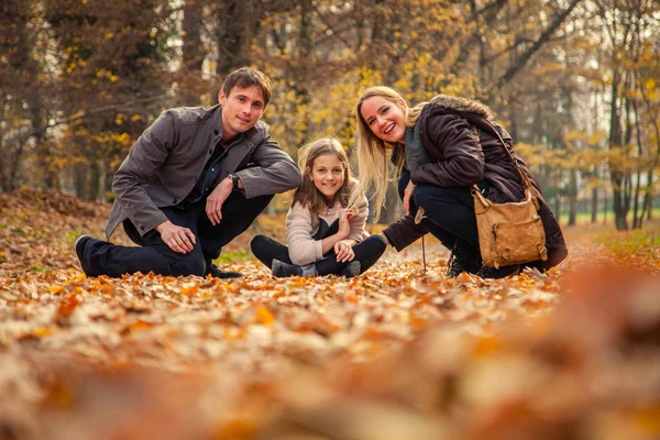 Family kneel on park ground — Stock Photo, Image