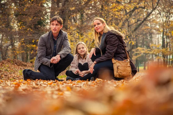 Family kneel on park ground — Stock Photo, Image