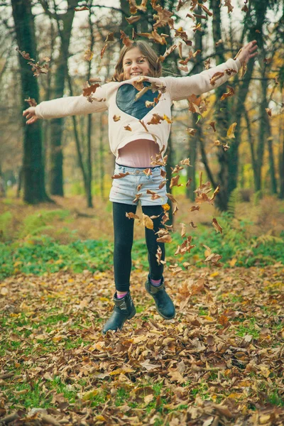 Child plays with leaves in park — Stock Photo, Image