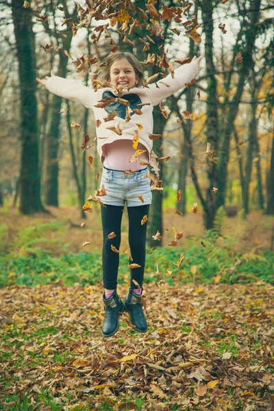 Child plays with leaves in park — Stock Photo, Image