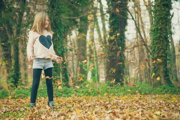 Дитина грає з листям у парку — стокове фото