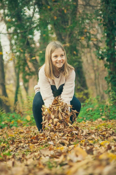 Kind spielt mit Laub im Park — Stockfoto