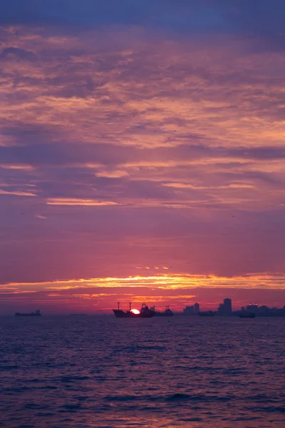 Båtar på horisonten vid solnedgången — Stockfoto
