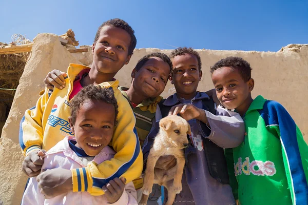 Chicos sosteniendo cachorro en Nubian pueblo —  Fotos de Stock