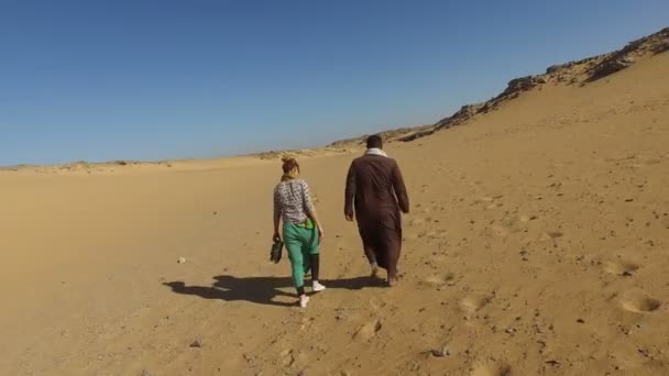 Homem nubiano andando no deserto com turista — Vídeo de Stock