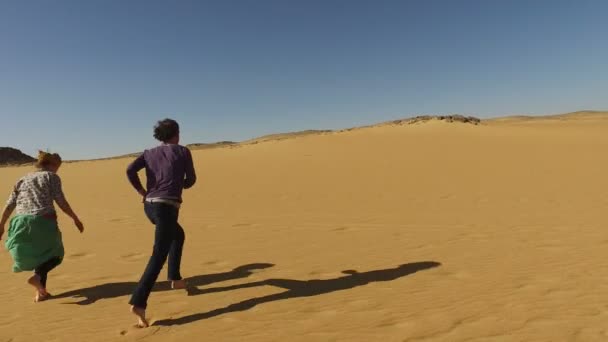 Couple running barefoot in desert — Stock Video