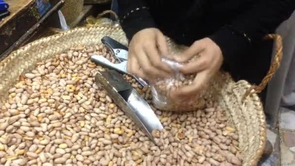 Ruce balení arašídů v plastovém sáčku — Stock video