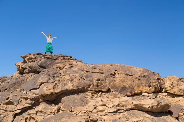 Tourist breitet Arme auf großem Felsen in Wüste aus — Stockfoto