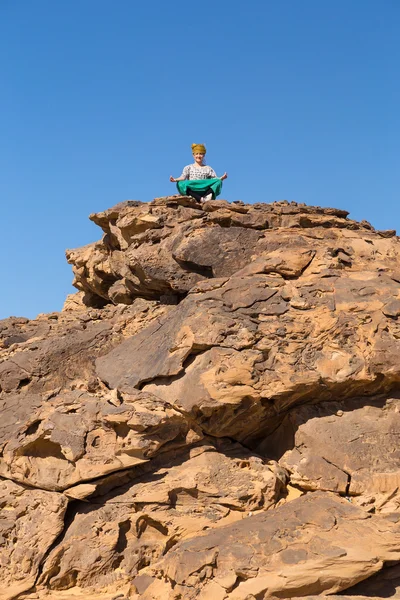 Turista meditando sobre rocha na sobremesa — Fotografia de Stock