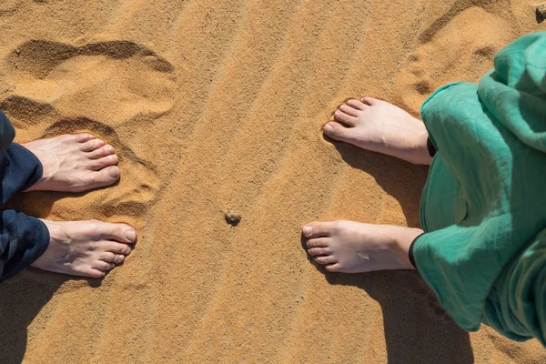 Male and female bare feet in the sand — Stock Photo, Image