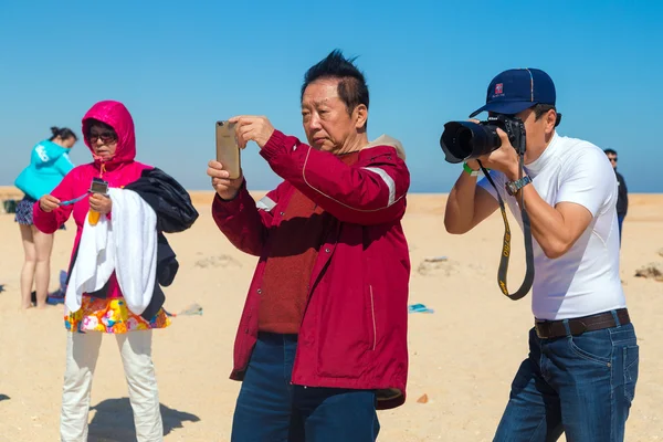 Turistas tomando fotos en la playa — Foto de Stock