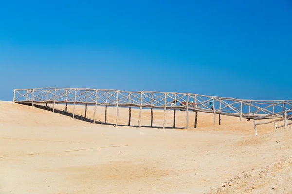 Ponte di legno sulla sabbia nel deserto — Foto Stock