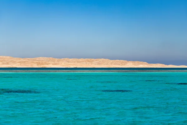 Mar azul-turquesa claro com deserto — Fotografia de Stock