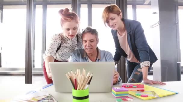 Kreativdirektor schaut mit Team auf Laptop — Stockvideo