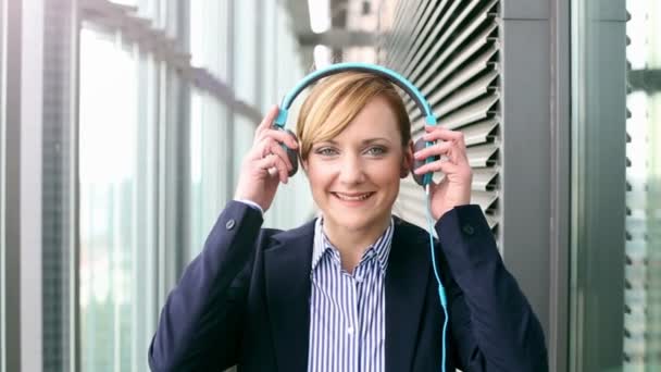 Mujer de negocios poniéndose auriculares — Vídeo de stock
